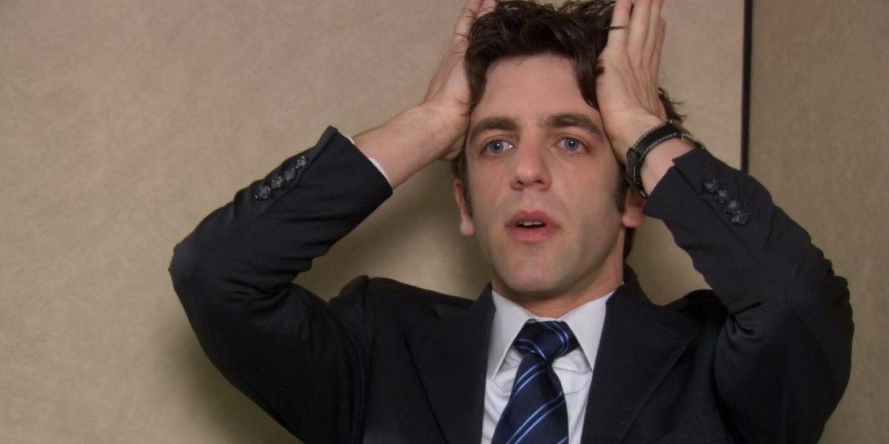 Ryan holding his head with his hands while talking to the camera in The Office