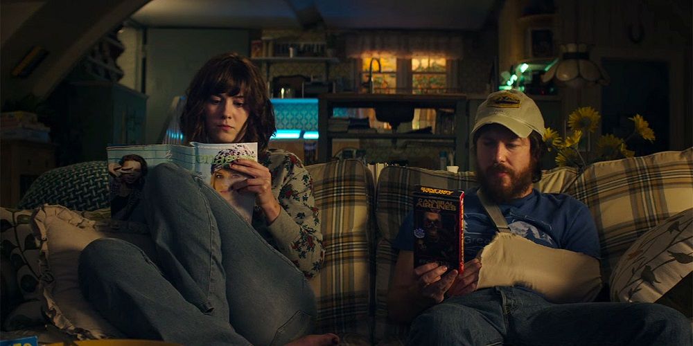 Michelle and Emmett sitting on the couch in 10 Cloverfield Lane
