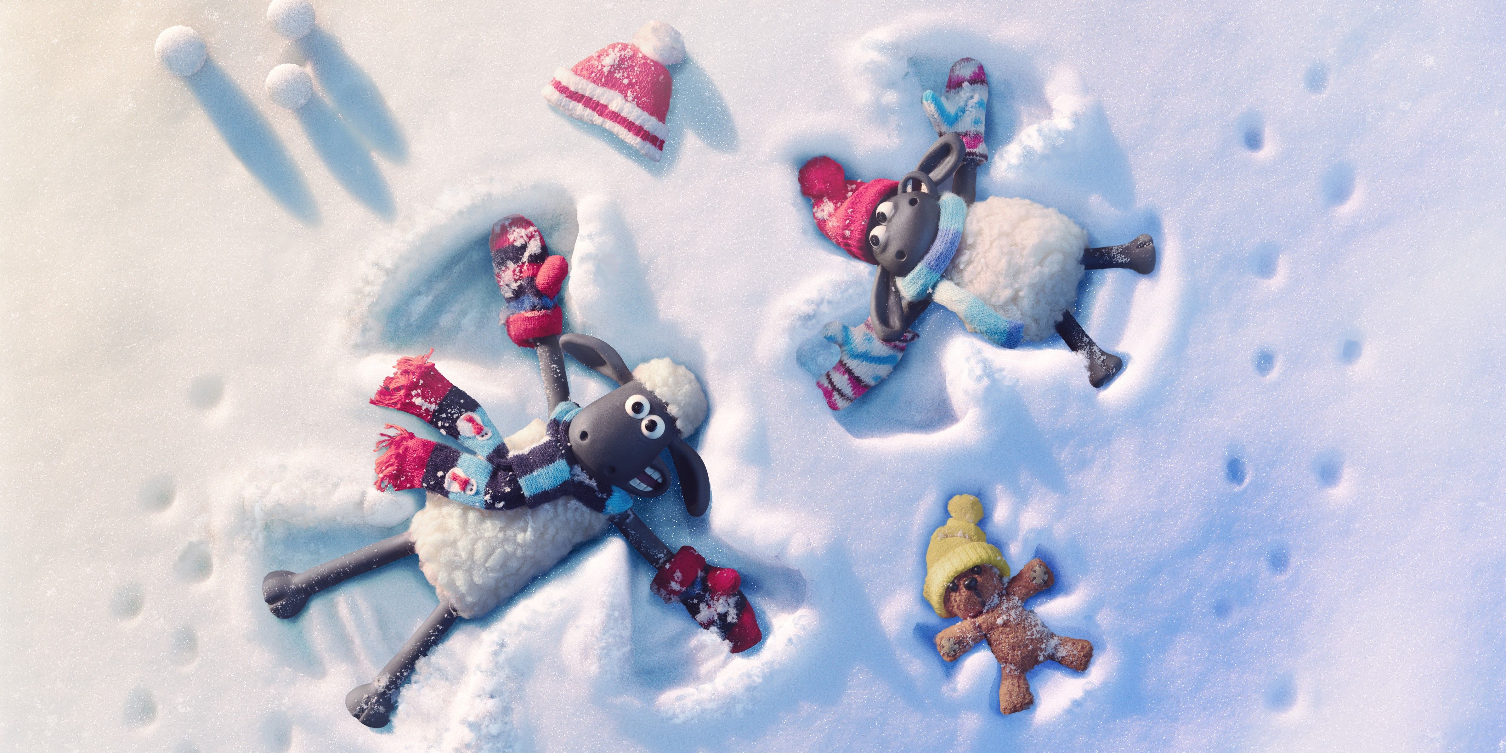 Characters from Shaun The Sheep: The Flight Before Christmas doing snow angels