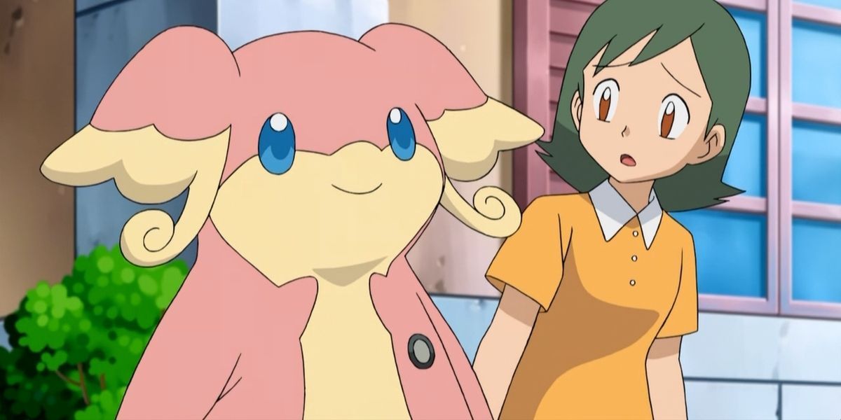 An Audino smiles while standing next to a confused-looking woman