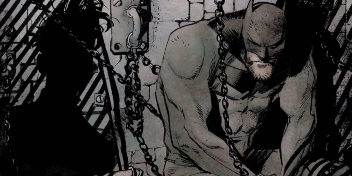 A disgraced, disheveled Batman chained to an Arkham Asylum cell wall in Batman: White Knight. 