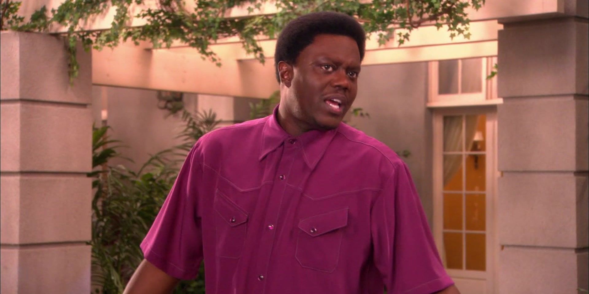 Bernie Mac standing outside in a purple shirt in The Bernie Mac Show