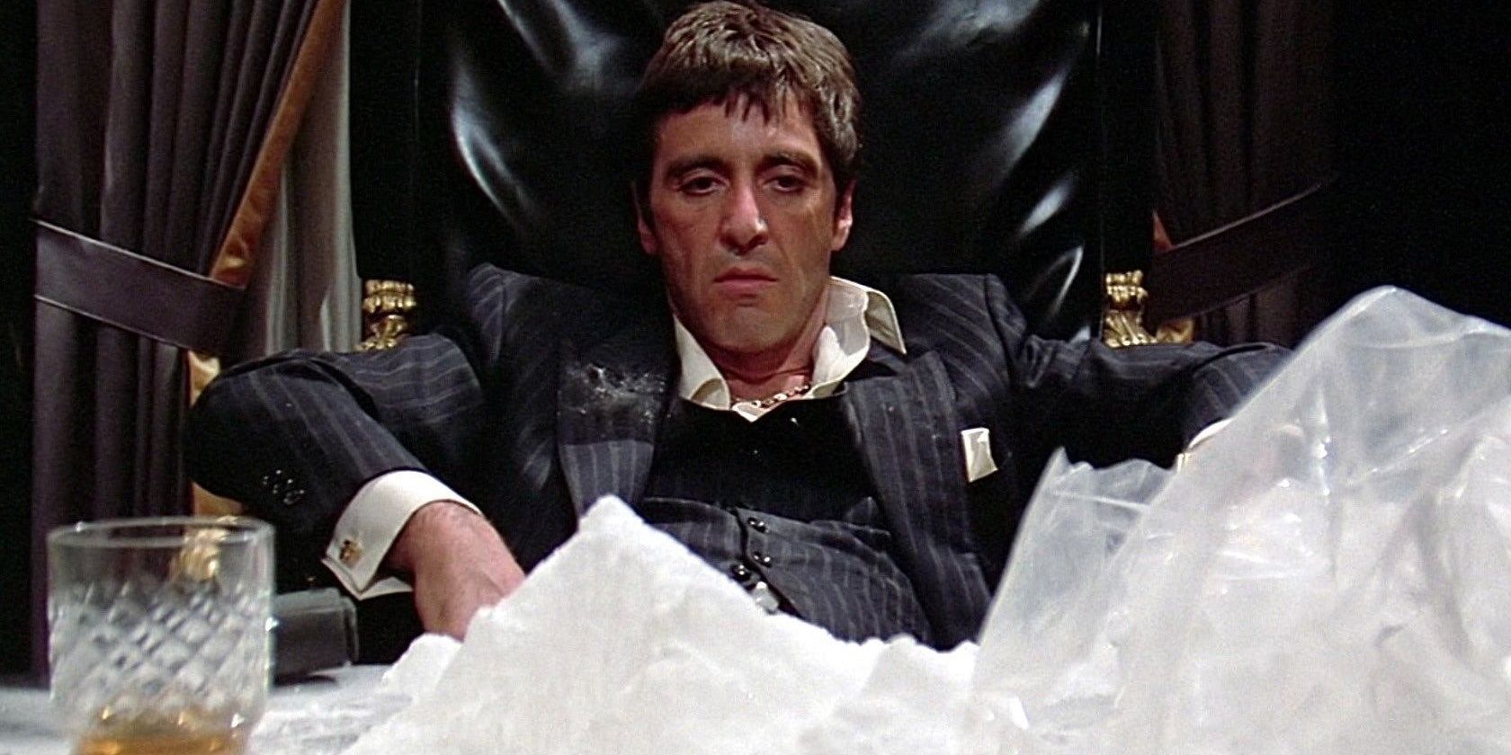 Tony Montana slouches in his seat as he looks at a mountain of cocaine on his desk in Scarface