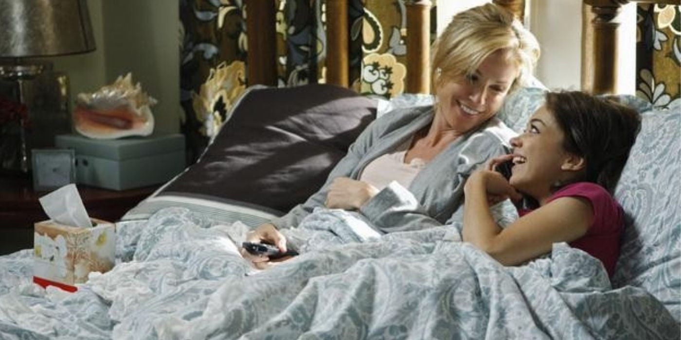 Claire and Haley in bed while sick - modern family