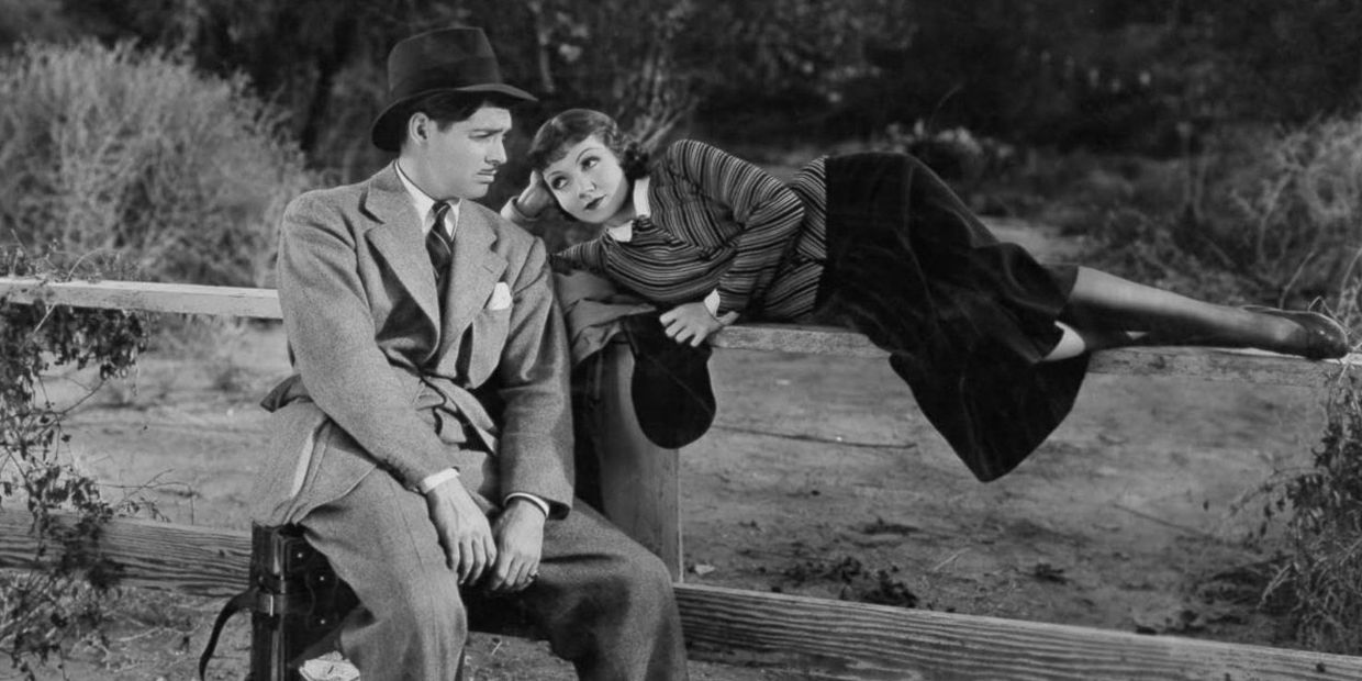 Clark Gable and Claudette Colbert sit together in It Happened One Night (1934)