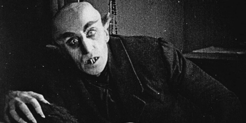 Count Orlok leaning over his would-be victim in Nosferatu