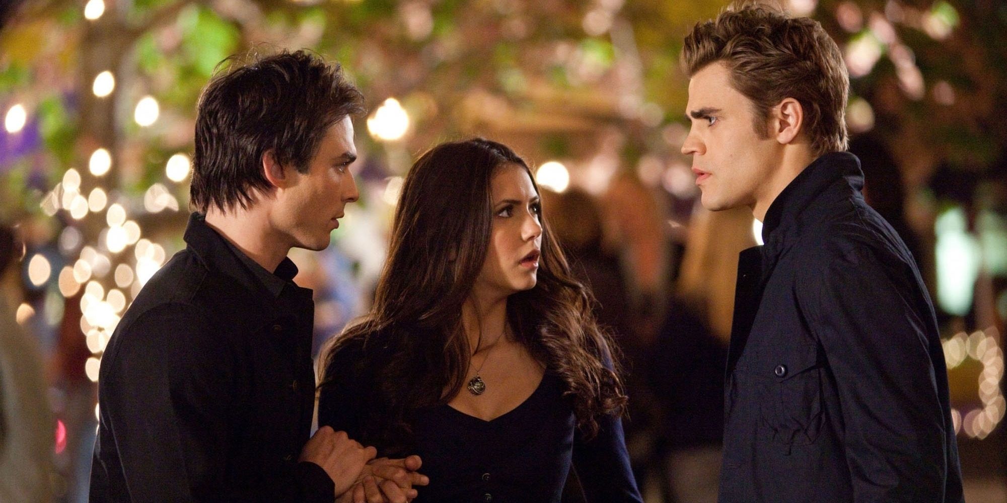 Elena looks between Damon and Stefan in The Vampire Diaries.