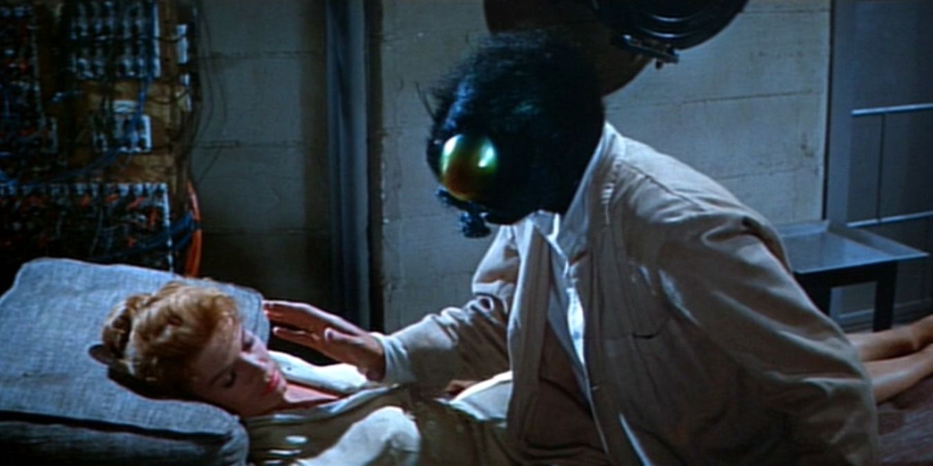 The title character in The Fly (1958) hovering over a sleeping woman on a gurney