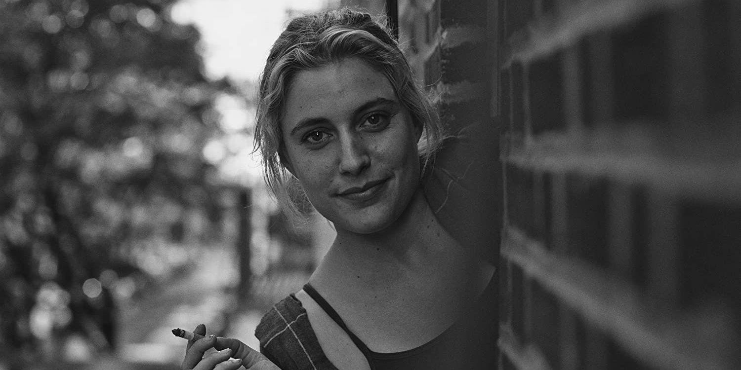 Frances sorrindo e segurando um cigarro em Frances Ha.