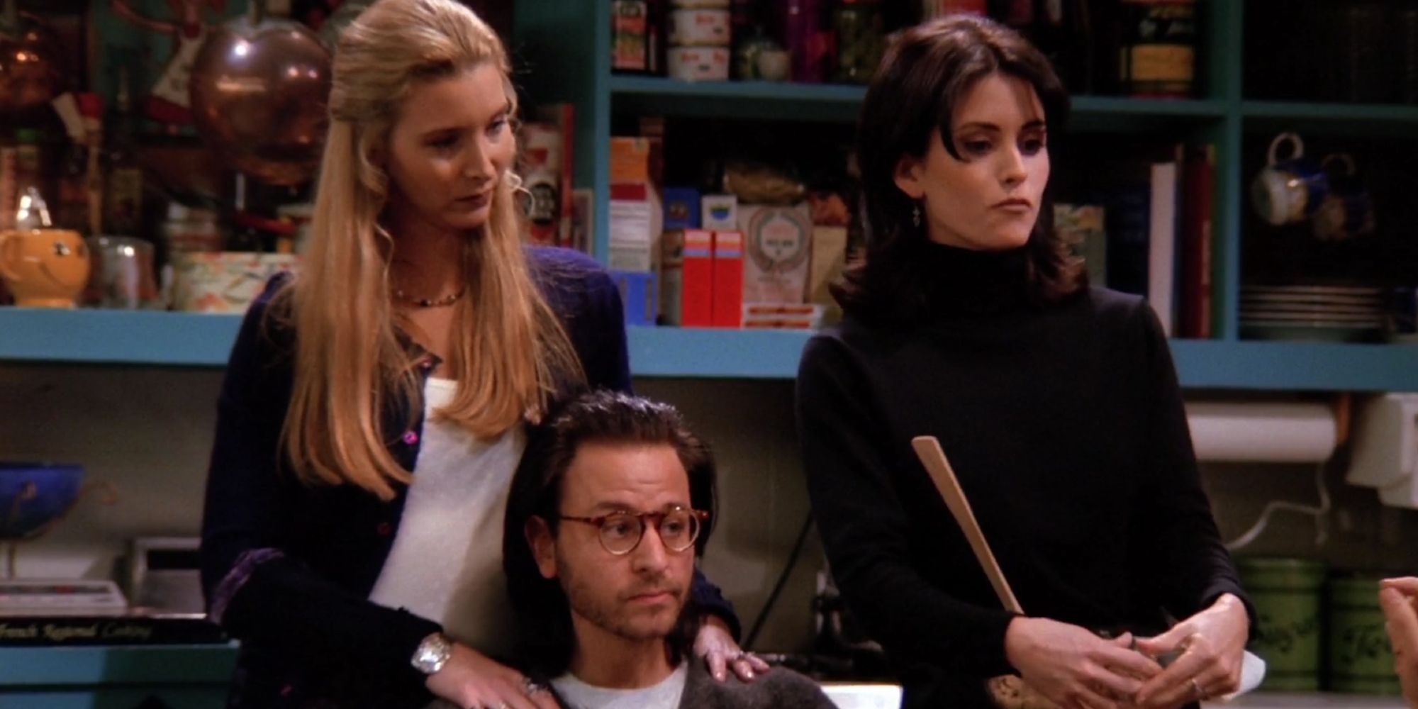 Phoebe e Monica na cozinha com Fisher Stevens como Roger em Friends