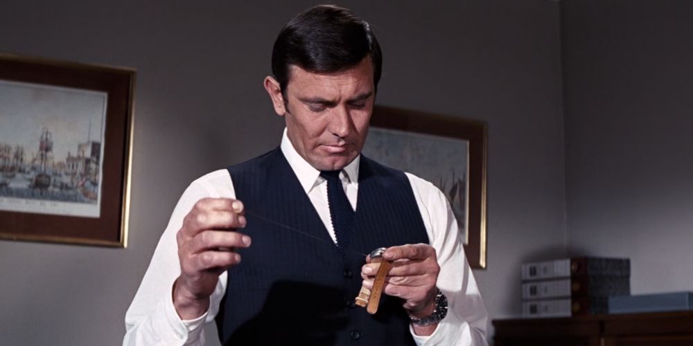 George Lazenby as 007 examining Red Grant's Watch in on her majesties secret service