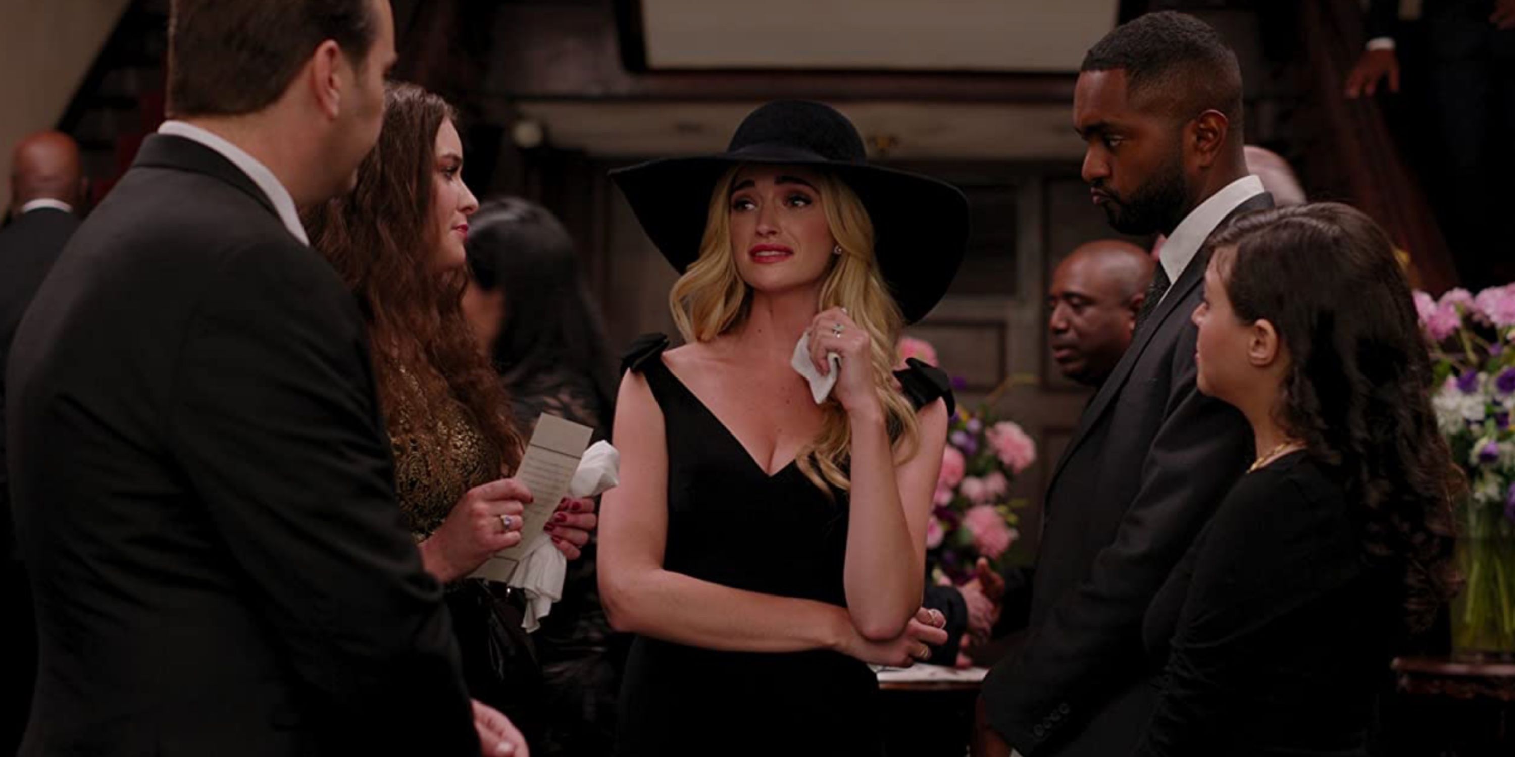 Brianne Howey in Ginny &amp; Georgia on Netflix at a funeral and holding a tissue.