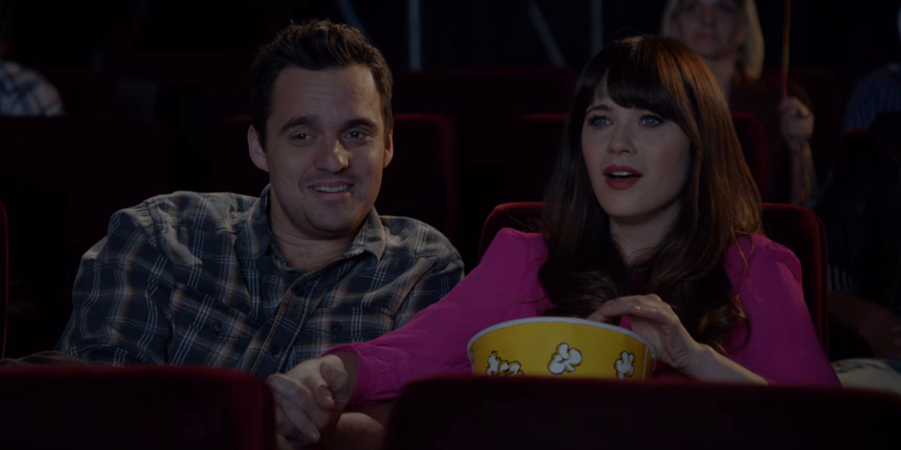 Nick and Jess sit together in a movie theater for her birthday celebration in New Girl
