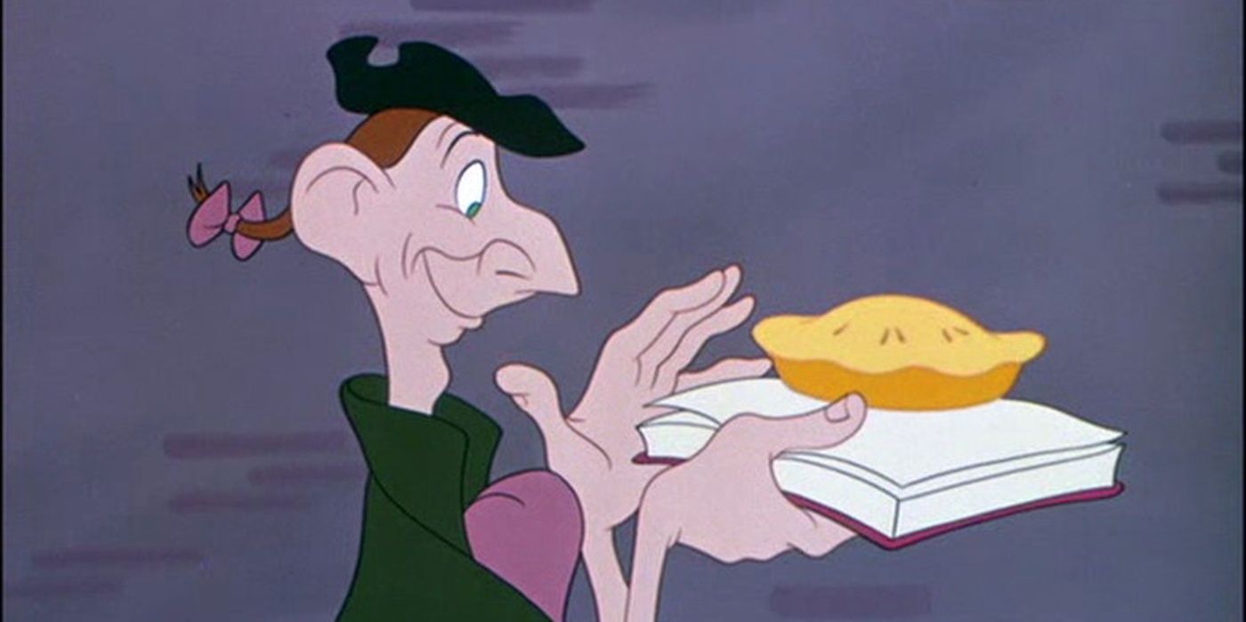 Ichabod Crane holds a pie on top of a book and smiles.