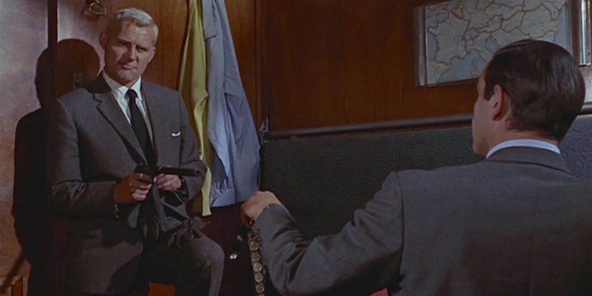 James Bond watches as Red Grant points a gun at him in From Russia with Love.