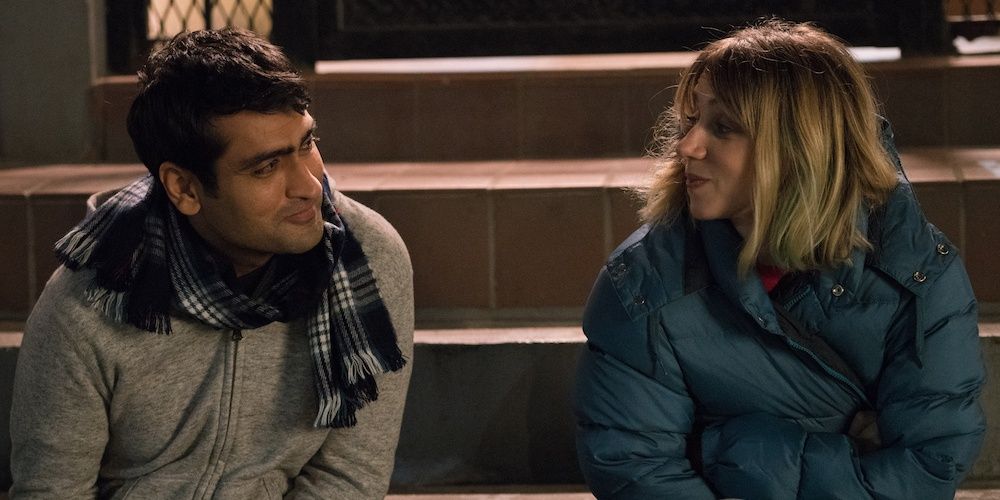 Kumail and Emily sit on a step outside in The Big Sick
