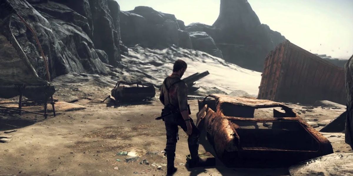 Mad Max stands by a rusty car body