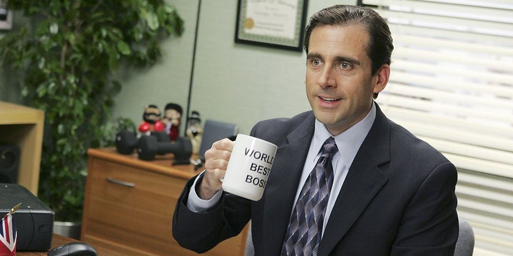 Michael Scott in his office, drinking out of his mug.
