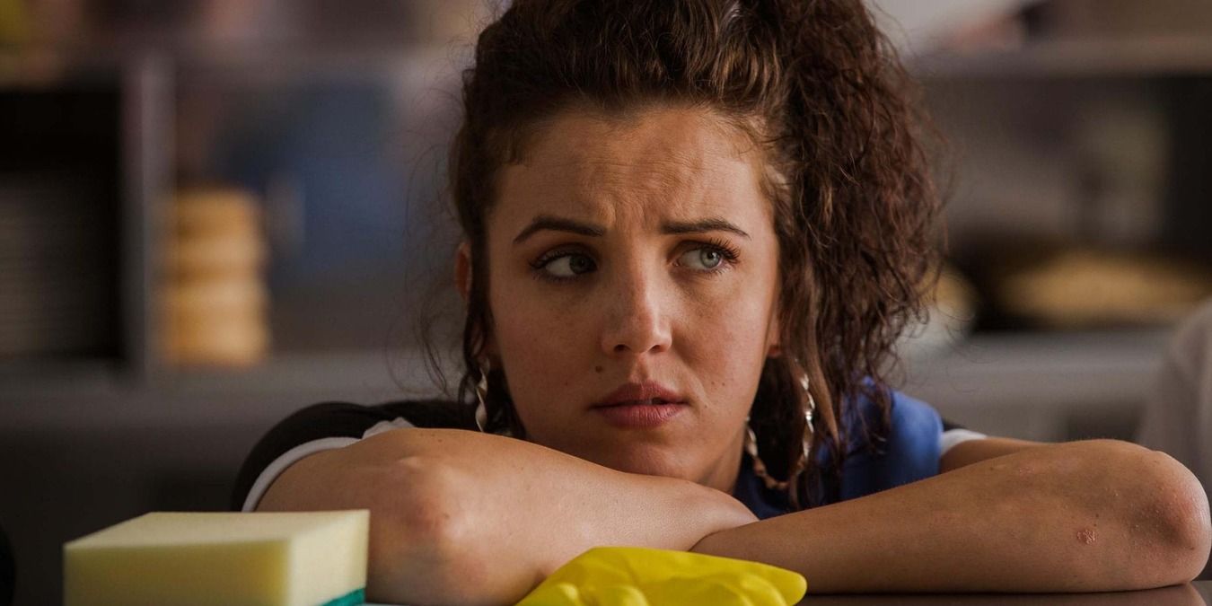 Michelle leans her head on her arms in Derry Girls