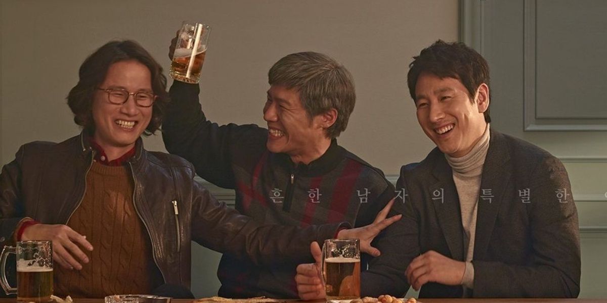 Personagens Dong-hoon, Ki-hoon e Sang-hoon comemorando e bebendo em uma mesa em My Mister