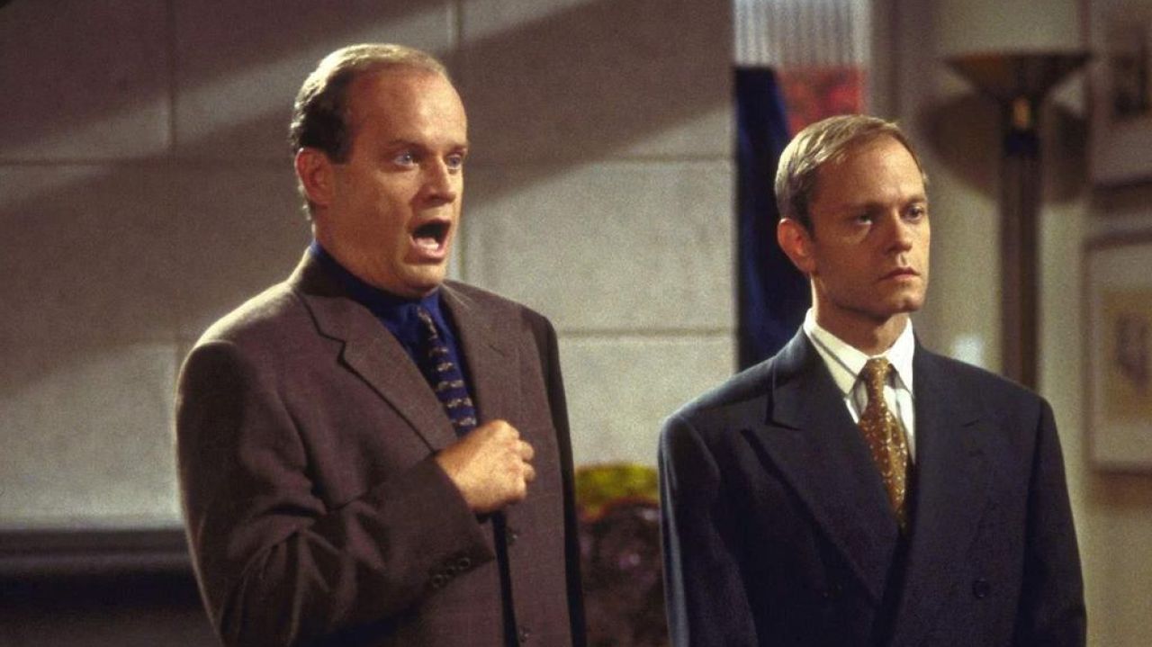 Niles standing next to Frasier in Frasier's apartment. 
