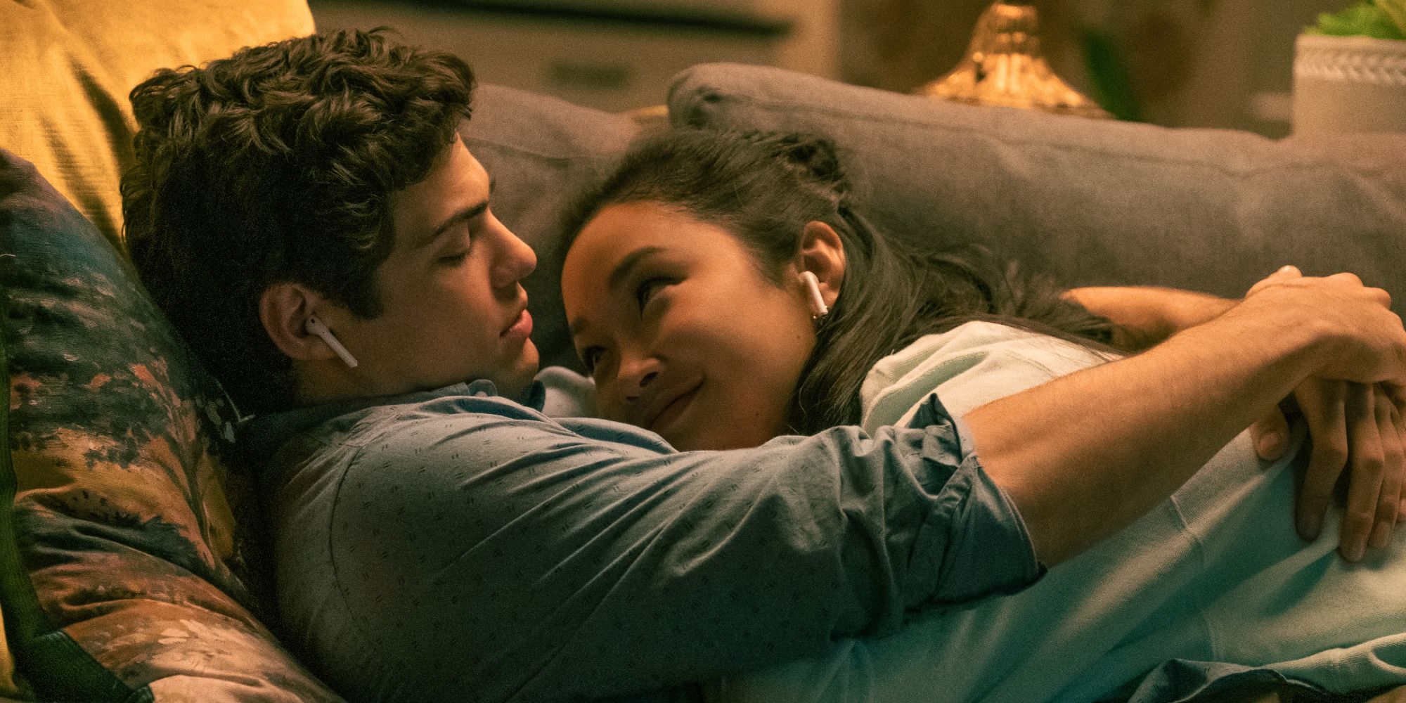 Peter and Lara Jean embrace on the sofa in To All The Boys I've Loved Before