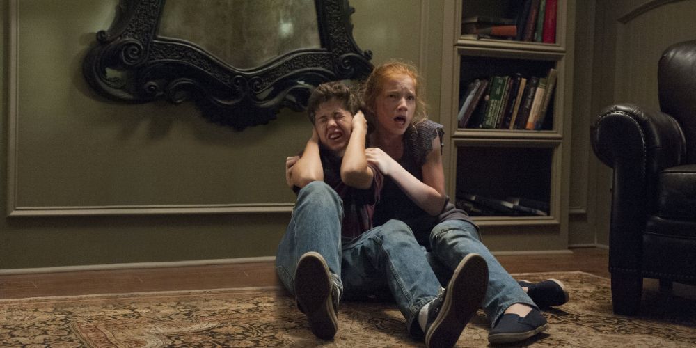 Young siblings Kaylie and Tim retreating under their possessed mirror in Oculus.