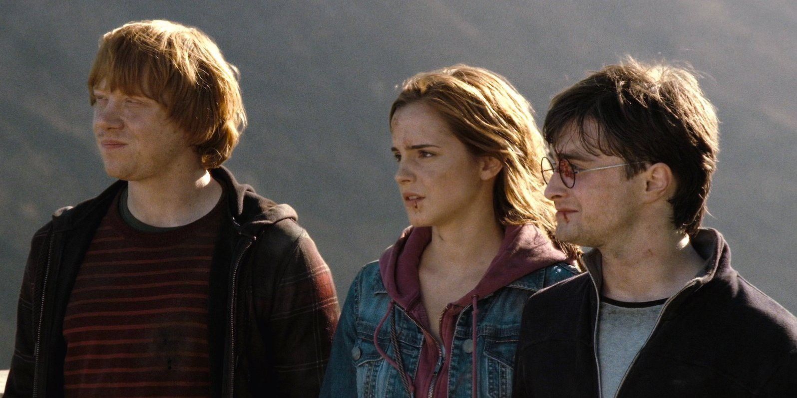 El trío de Harry Potter mirando fuera de la pantalla en Las Reliquias de la Muerte