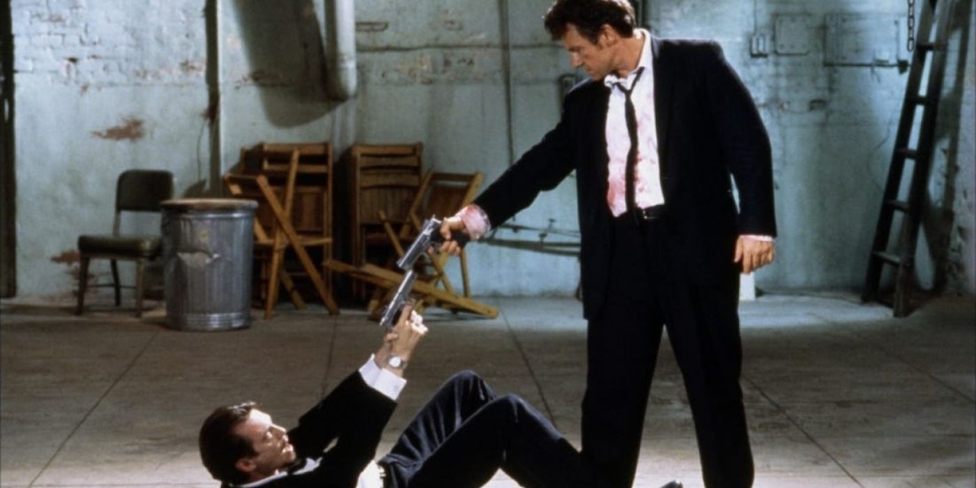 Mr. White and Mr. Pink point their guns at each other in the warehouse in Reservoir Dogs