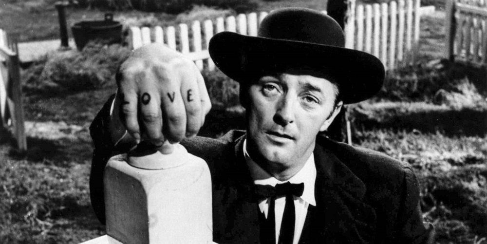Robert Mitchum in The Night of the Hunter holding onto a patio railing and looking at the camera.