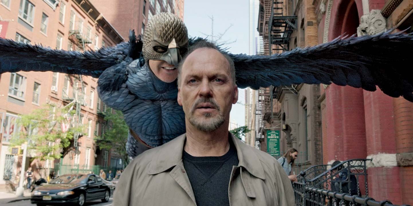 Michael Keaton as Riggan walking down in the street in Birdman while Birdman hovers behind him