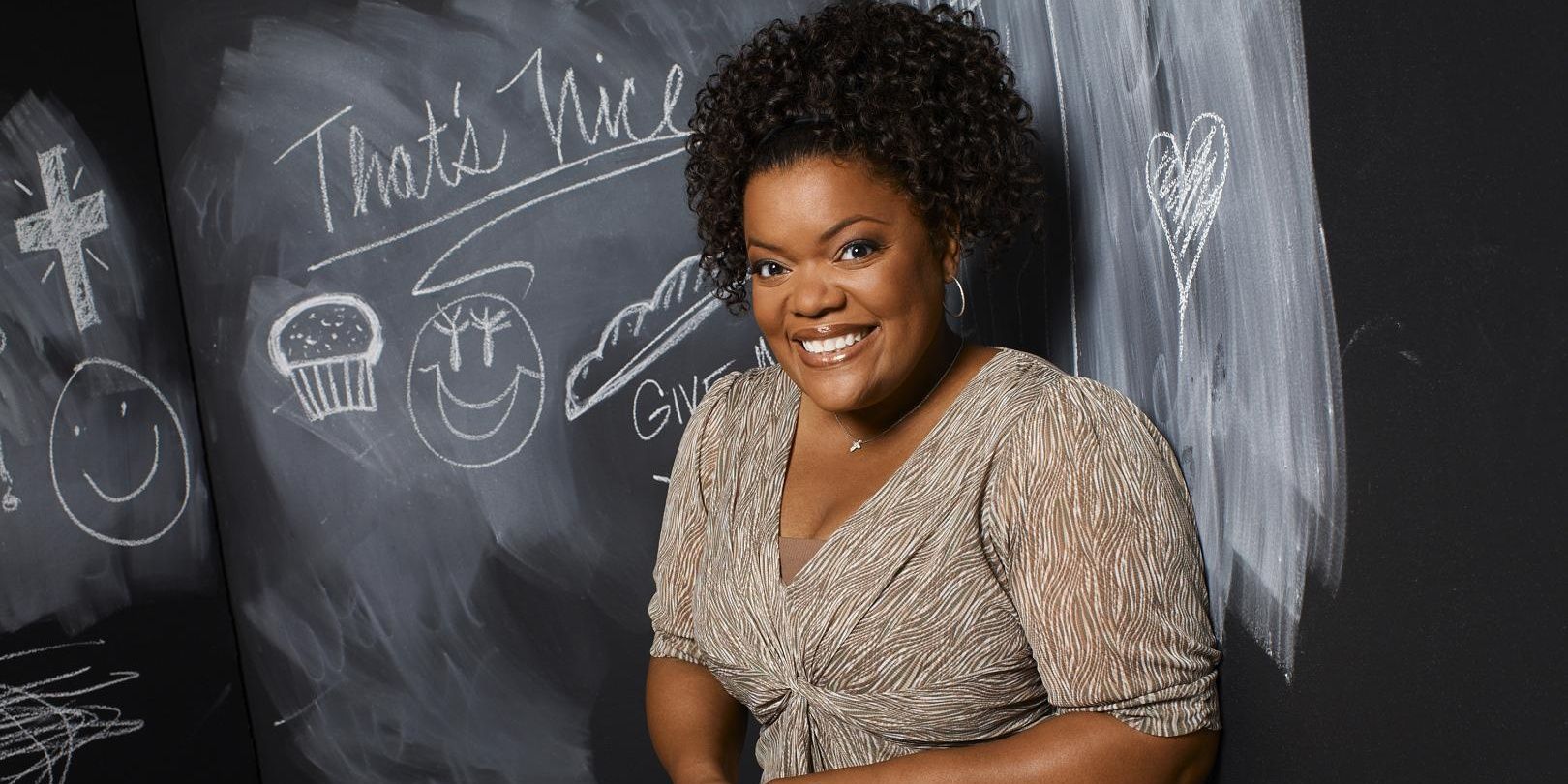 Shirley Bennett smiling next to a blackboard