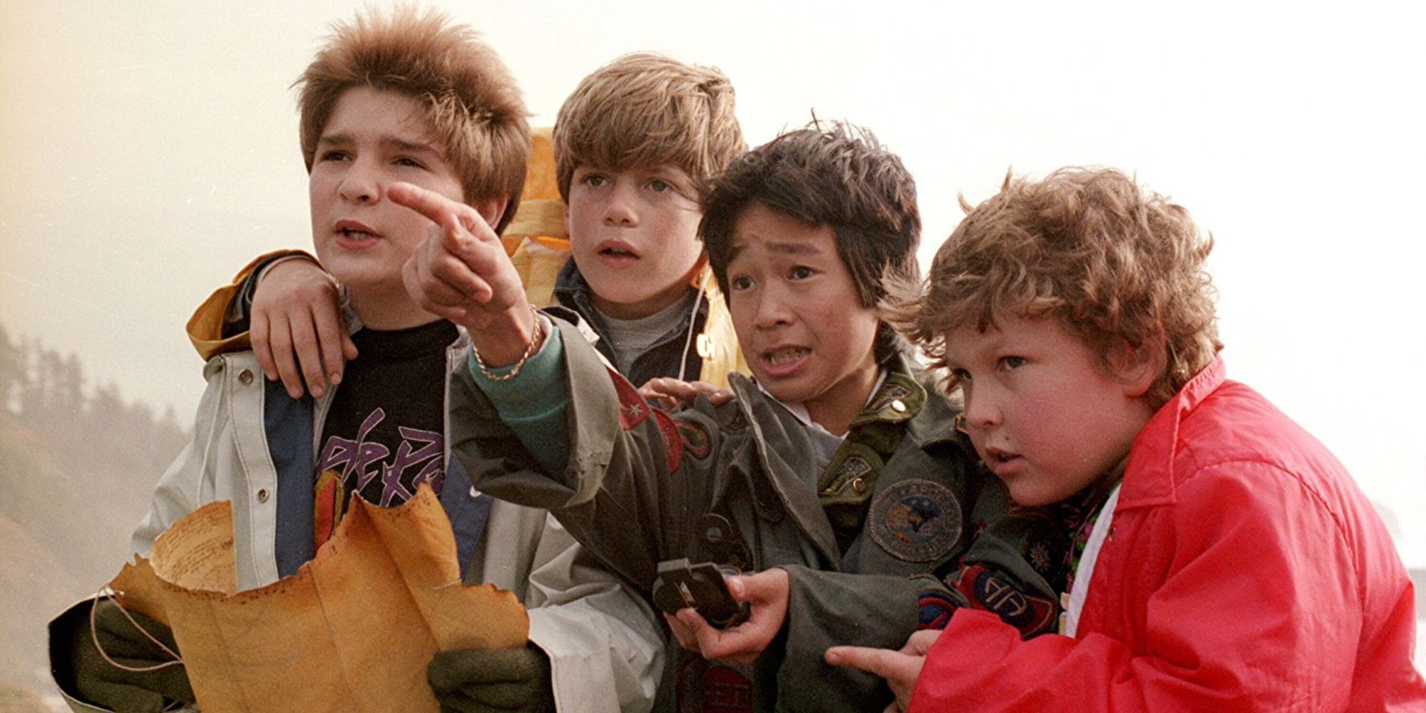 Data points at something with Mouth, Chunk, and Mikey beside him in Goonies.