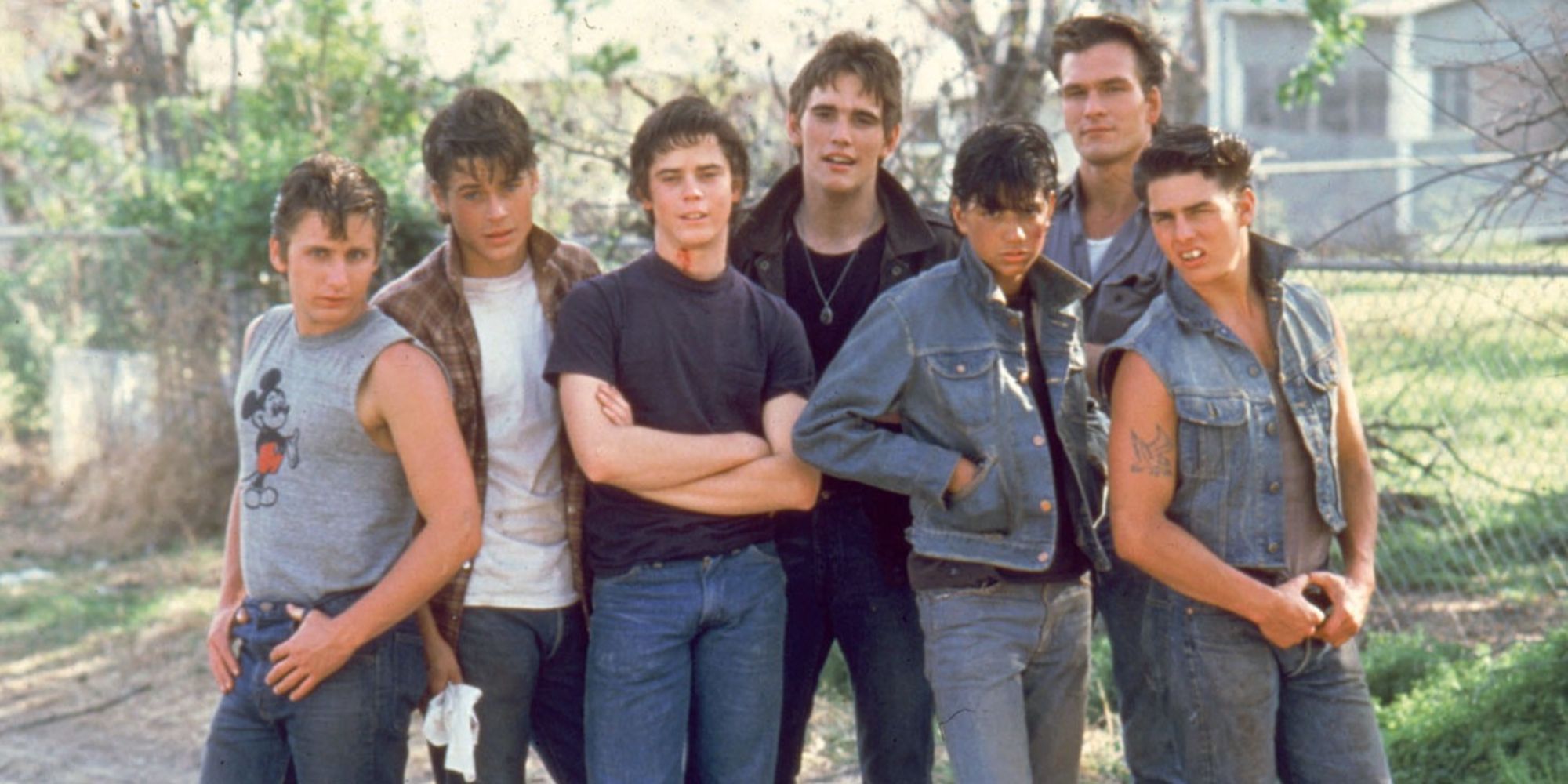 The cast of The Outsiders standing close together outside
