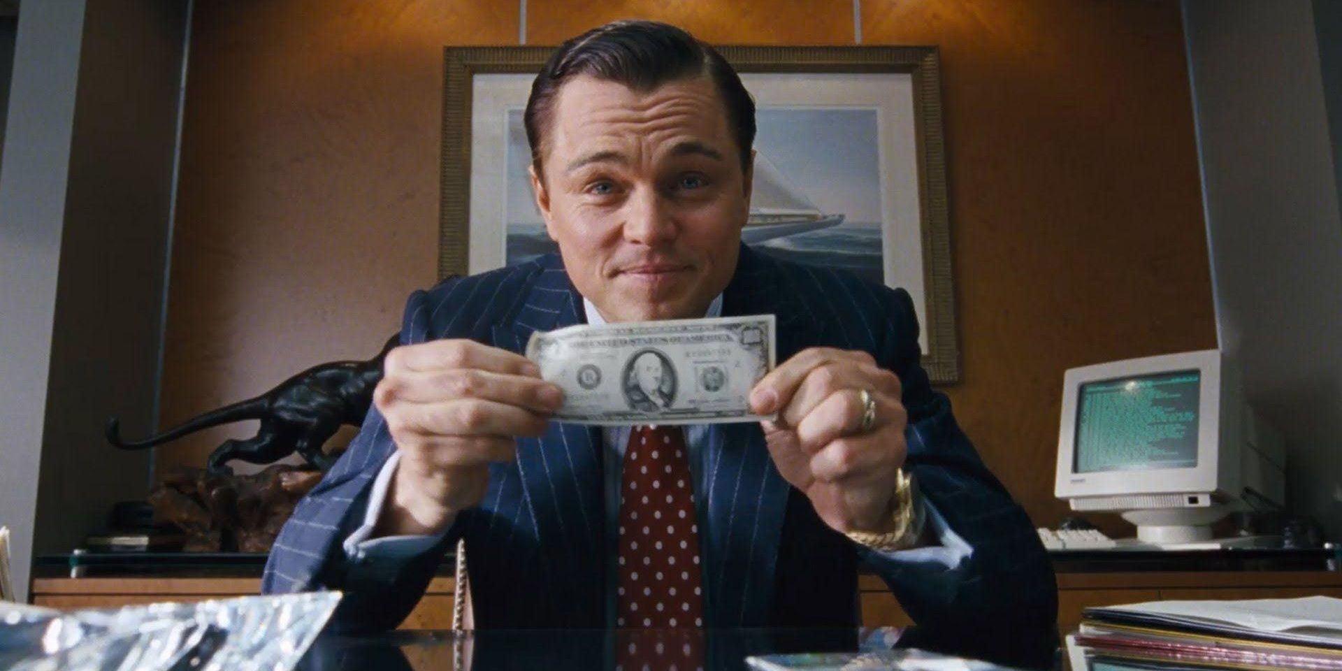 Jordan Belfort holding money in The Wolf of Wall Street