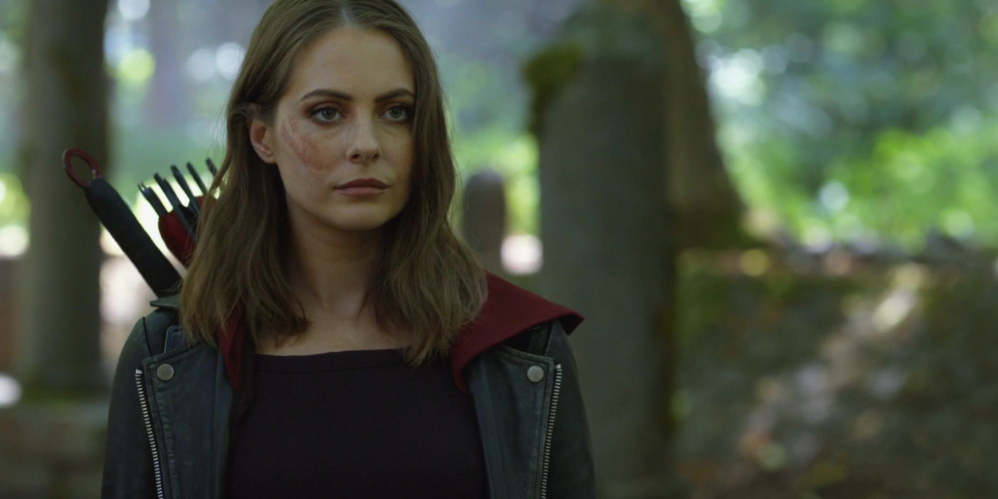 An image of Thea Queen standing in a field in Arrow