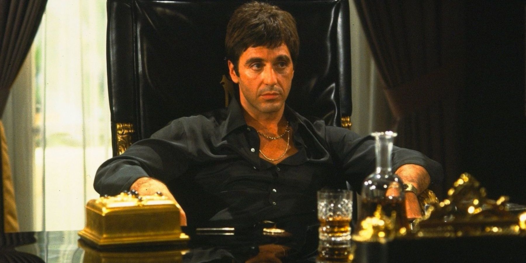Al Pacino sitting at a desk in Scarface