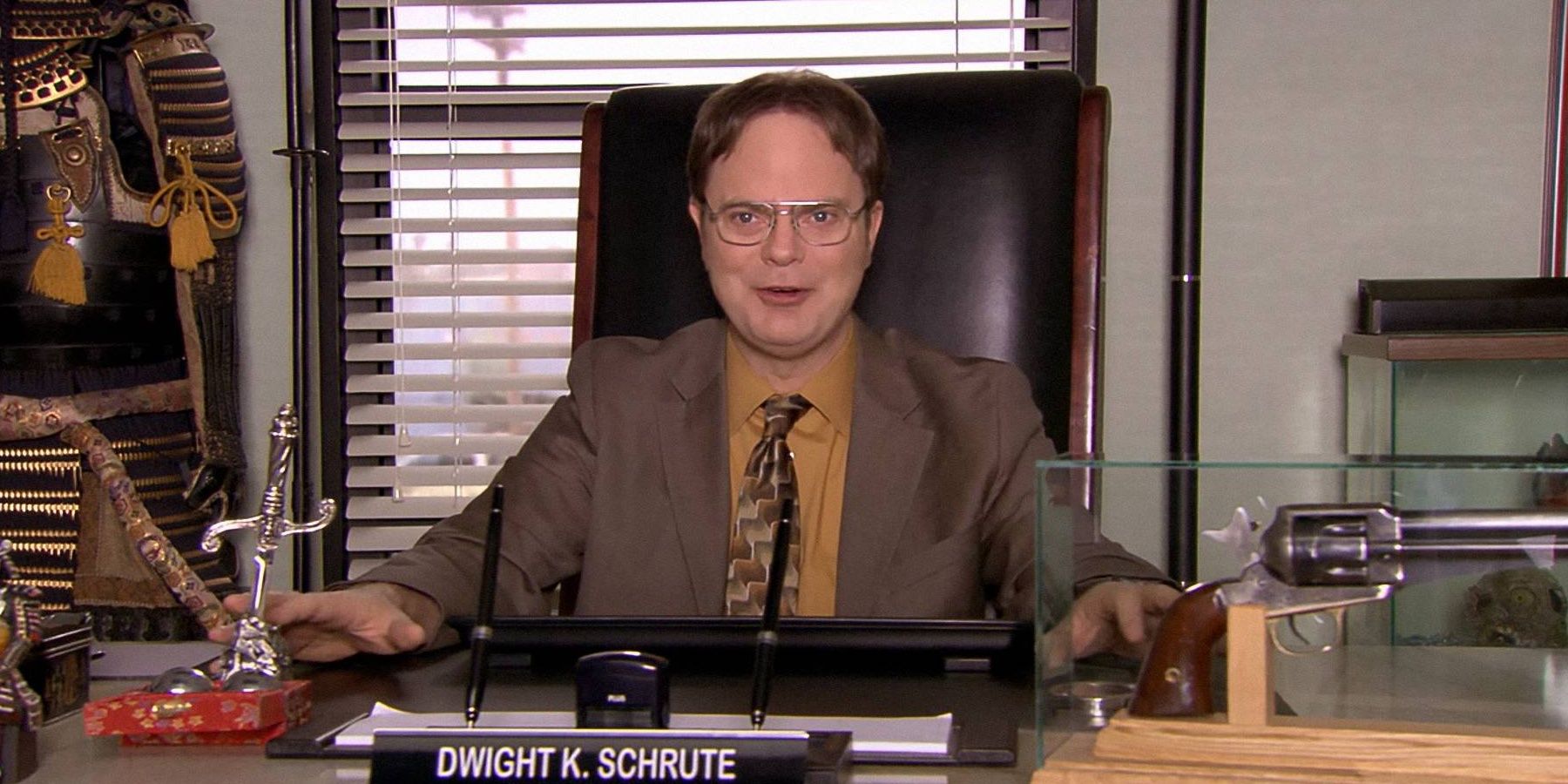 Dwight excitedly sits in his office as manager of Dunder Mifflin in The Office