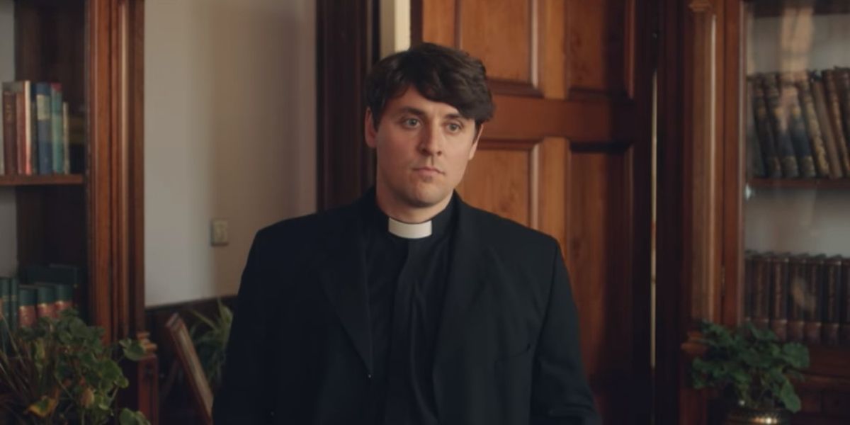 Father Peter standing in an office in Derry Girls