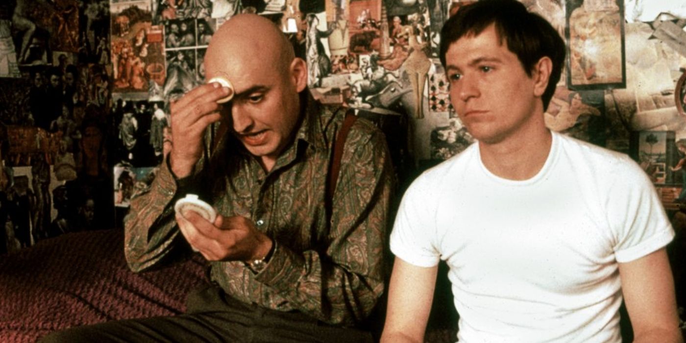 Gary Oldman as Joe Orton sitting infront of a wall full of pictures in Prick Up Your Ears