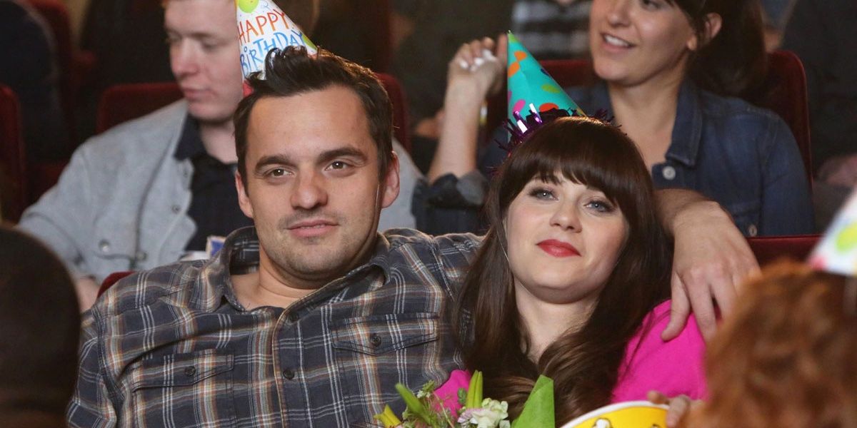 Nick with his hands around Jess, both with Birthday hats in New Girl