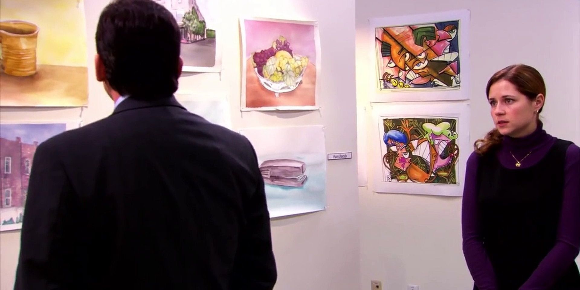 Michael looks at Pam's art as she watches him on The Office.