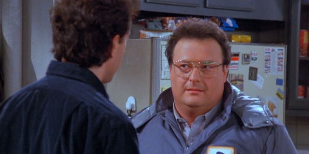 Newman in his postal service jacket on Seinfeld, talking to Jerry in his kitchen.