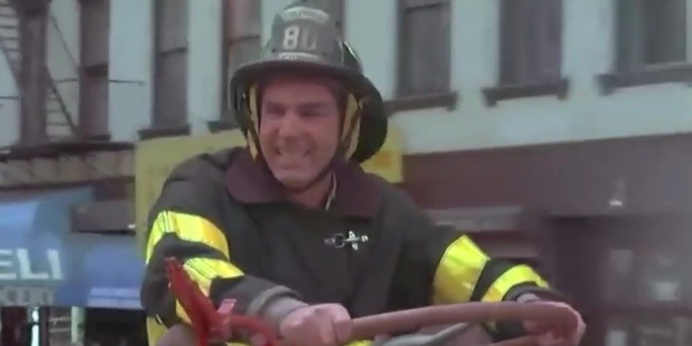 Kramer behind the wheel of a fire truck dressed as a fireman