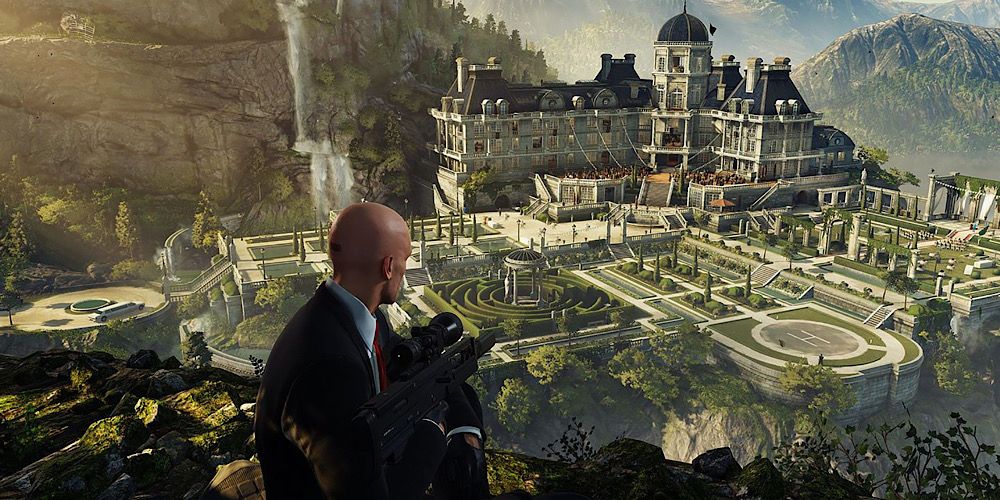 Agent 47 perches on a cliff edge overlooking a beautiful mansion