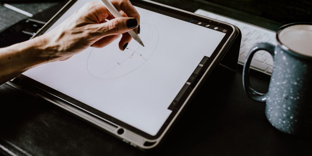 A person drawing a picture on a 2 in 1 laptop with a stylus