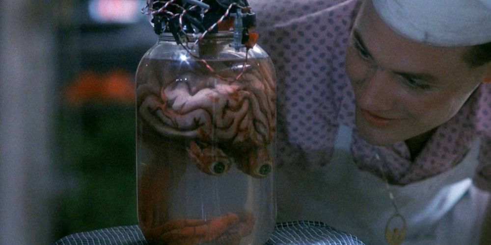 A male chef looking into a jar that contains a brain in Blood Diner