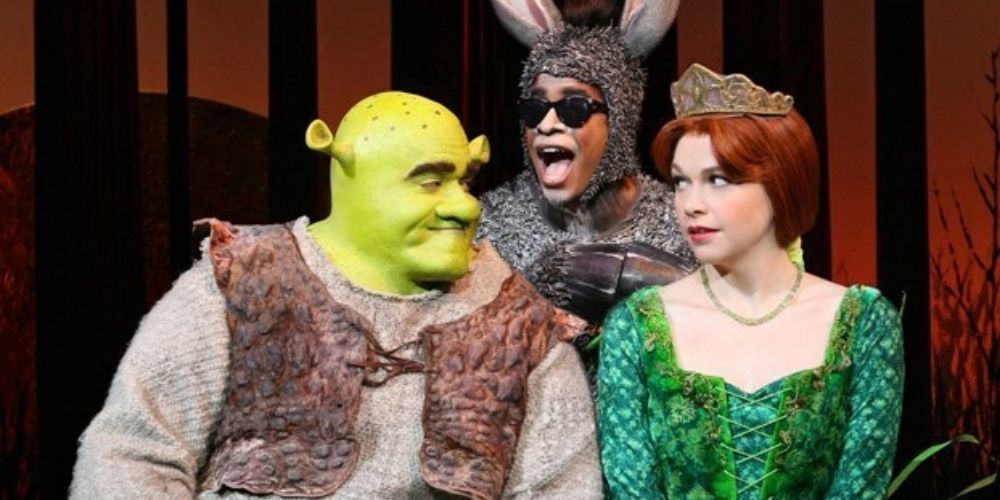Shrek, Fiona, and Donkey on stage in Shrek the Musical