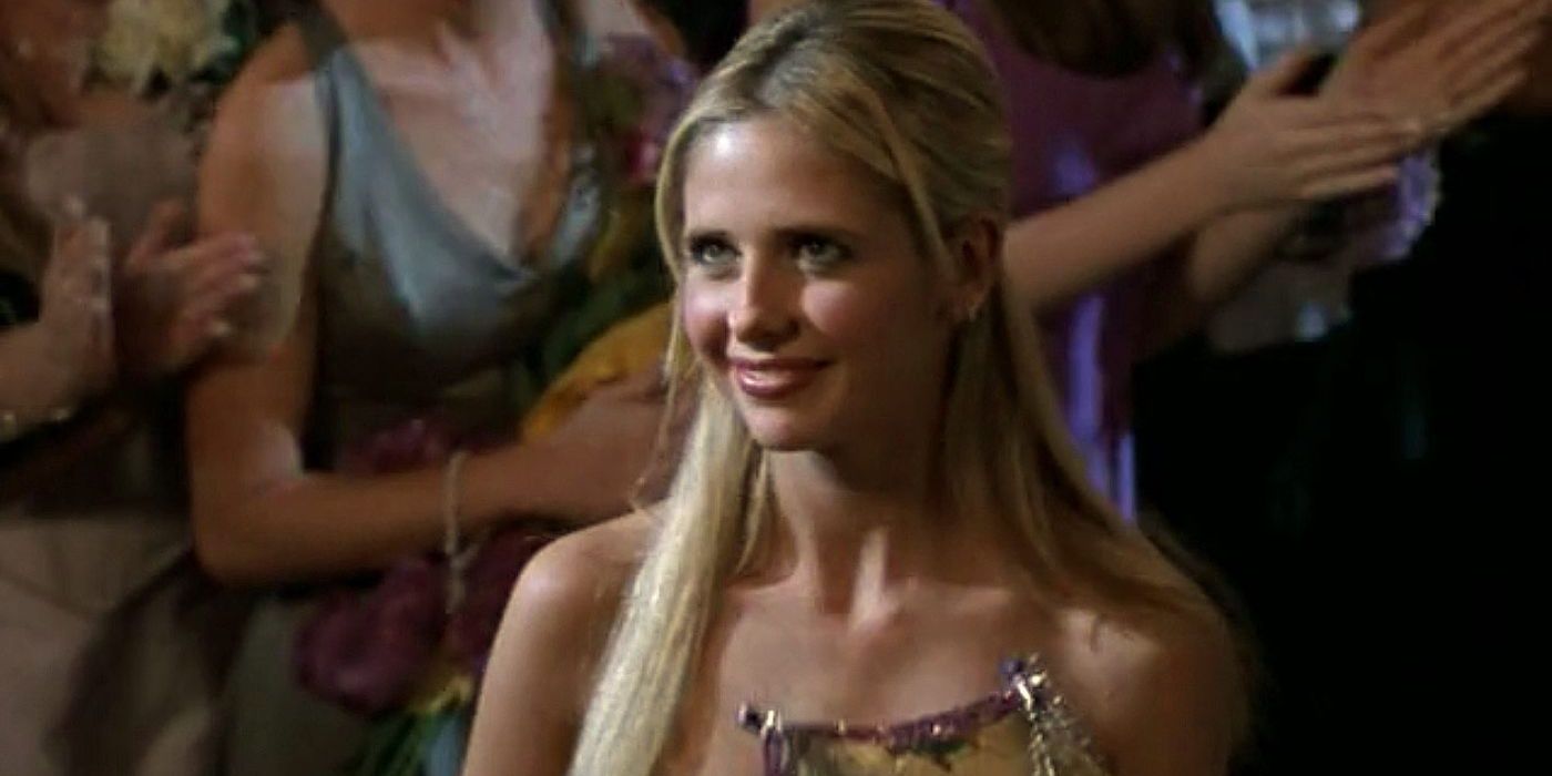 An image of Buffy receiving the class protector award. She is wearing her prom outfit although the dress is not in the shot completely. She is also seen wearing her hair down and smiling 