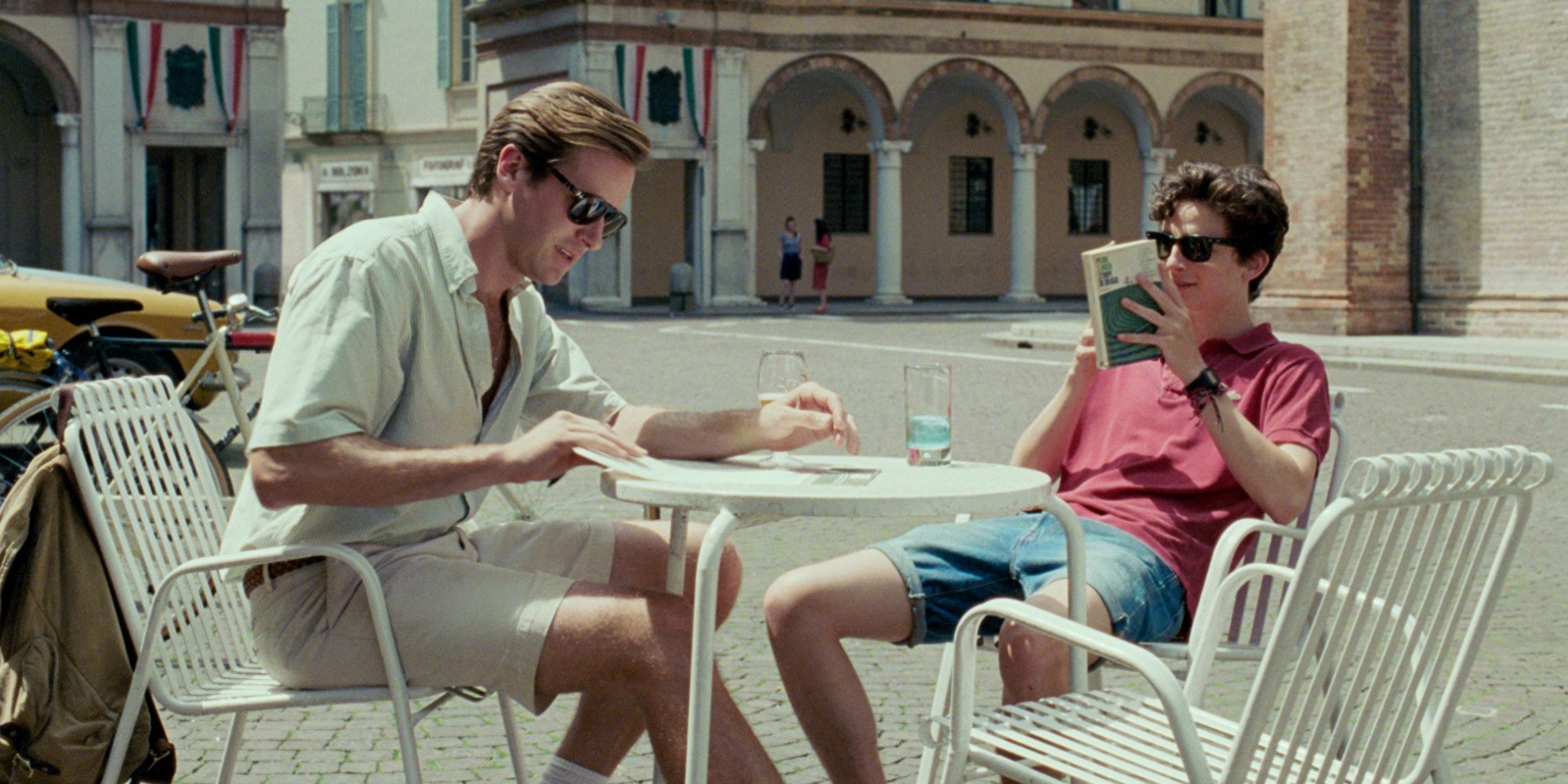 Hammer and Chalamet in Call Me By Your Name sitting at cafe chairs outside